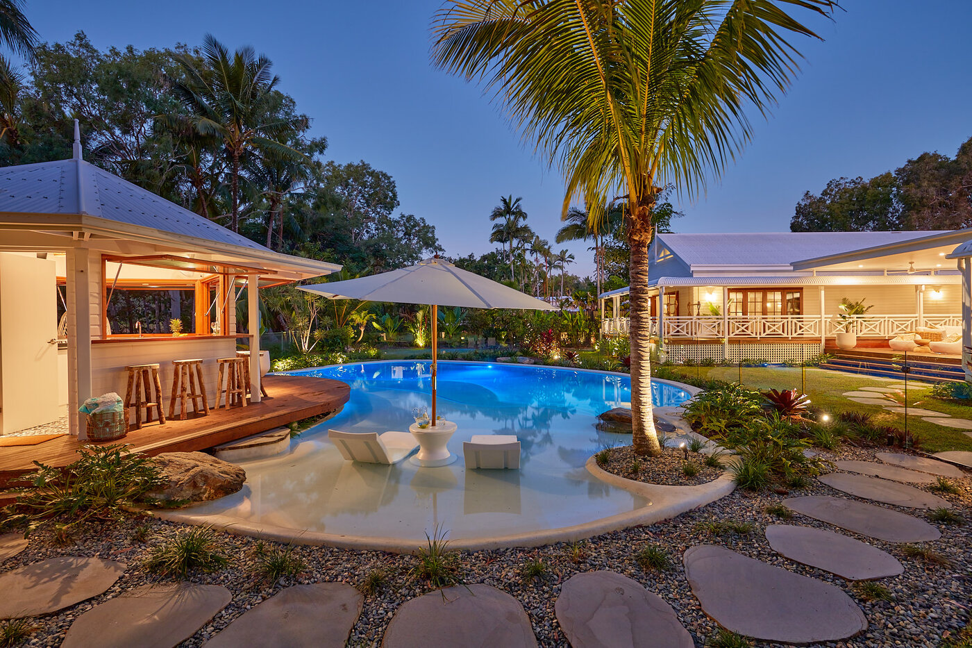 Night Photo of Resort Style Pool with cabana, landscaping, lighting & audio