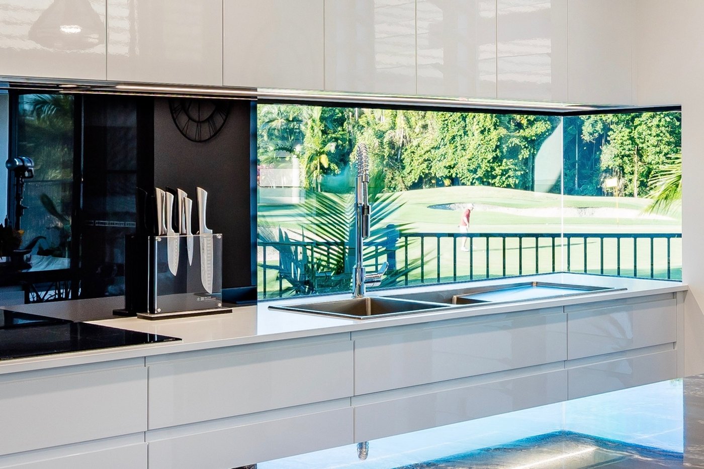 White custom designed kitchen with corner bay window overlooking golf course