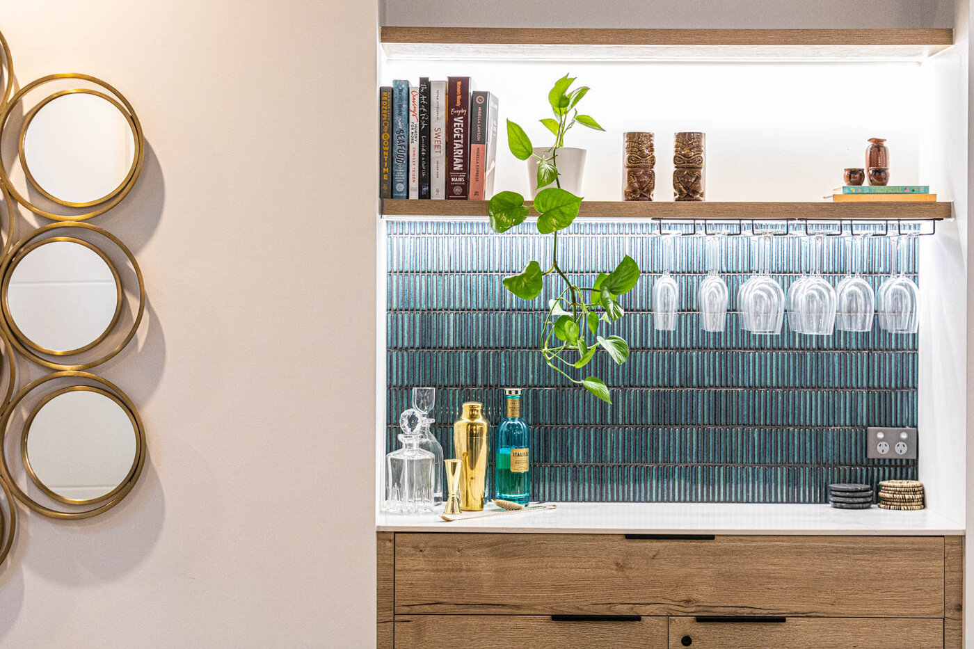 Built in bar area with hanging glasses and cupboards